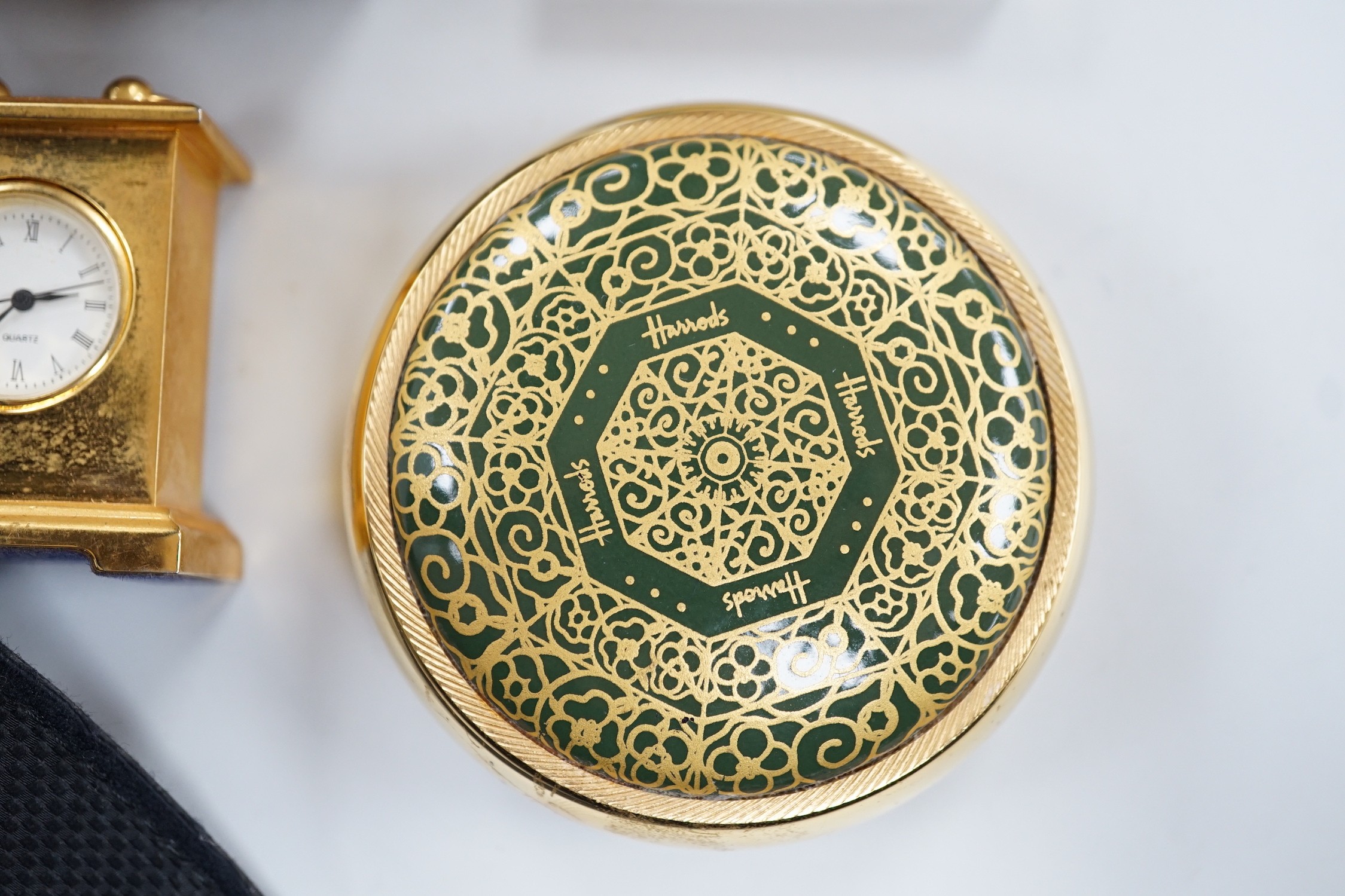 A Halcyon Days Harrods paperweight, a Halcyon Days timepiece and three other timepieces